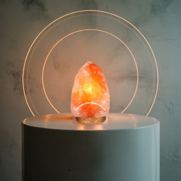 A glowing Himalayan salt lamp sits atop a white pedestal, casting a warm, inviting light in the surrounding space.